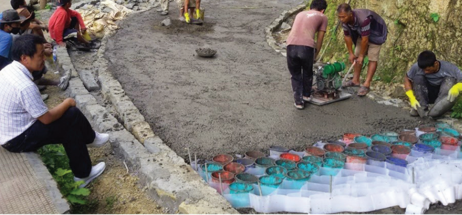 Plastic cells made from plastic waste are filled with concrete and compacted by a plate vibrator to build roads. Photo credit: ADB.
